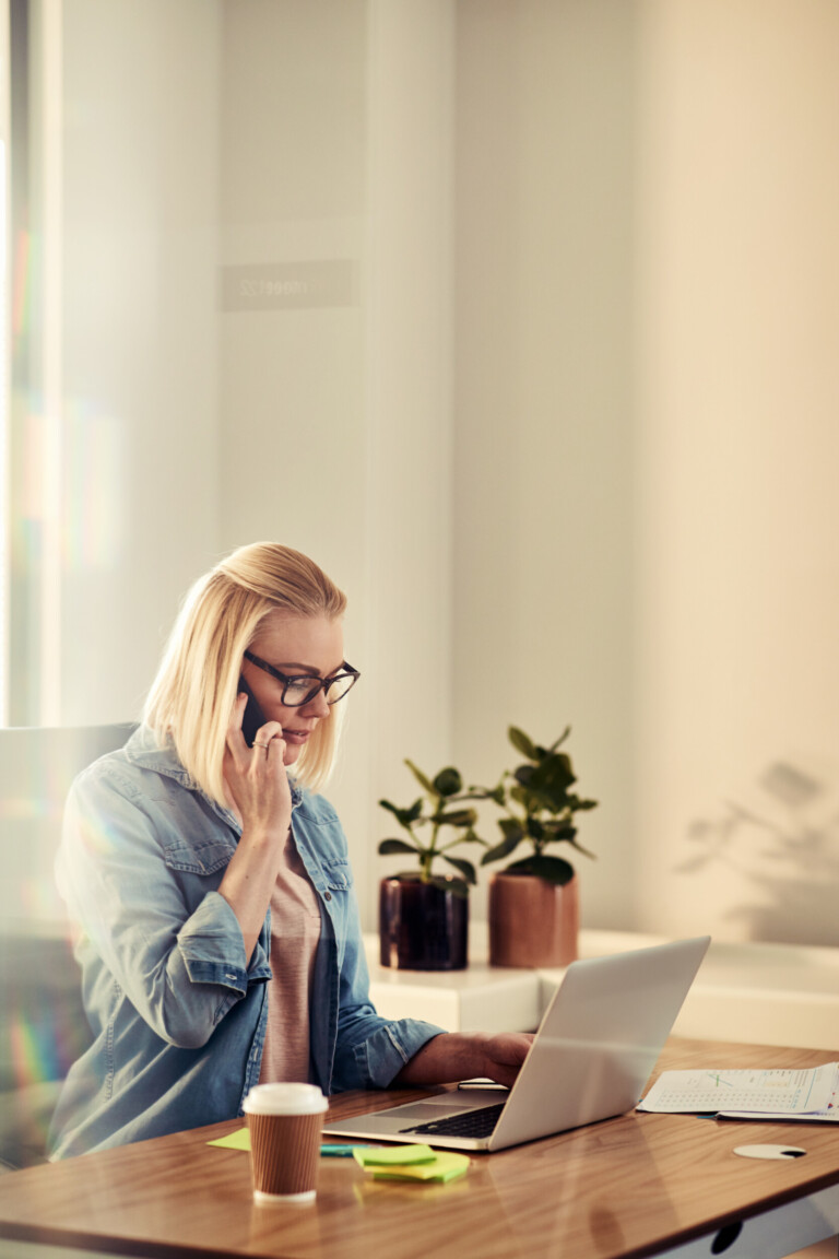 focused young businesswoman talking on a cellphone in her office