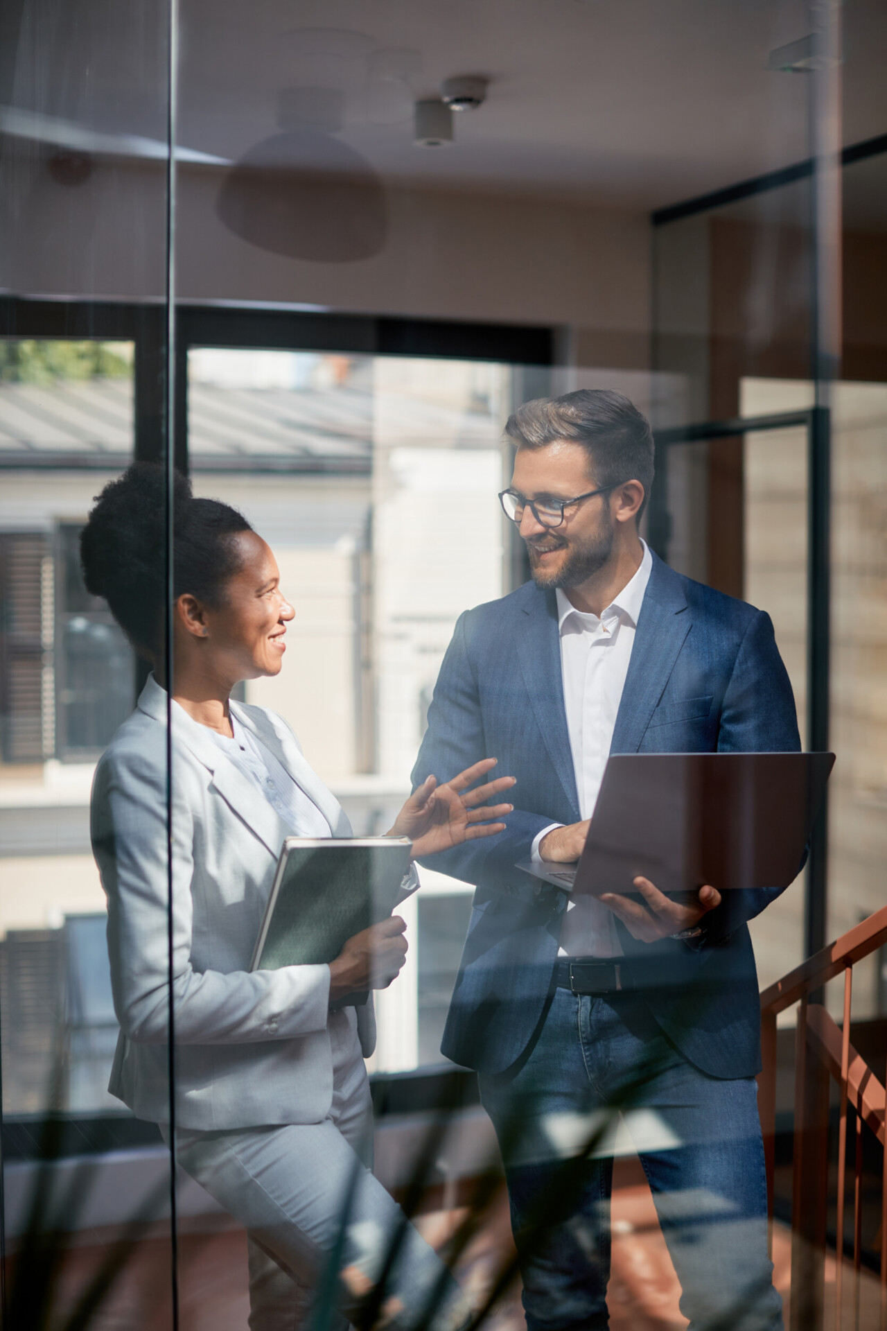 happy business colleagues talking while working on laptop in the office.