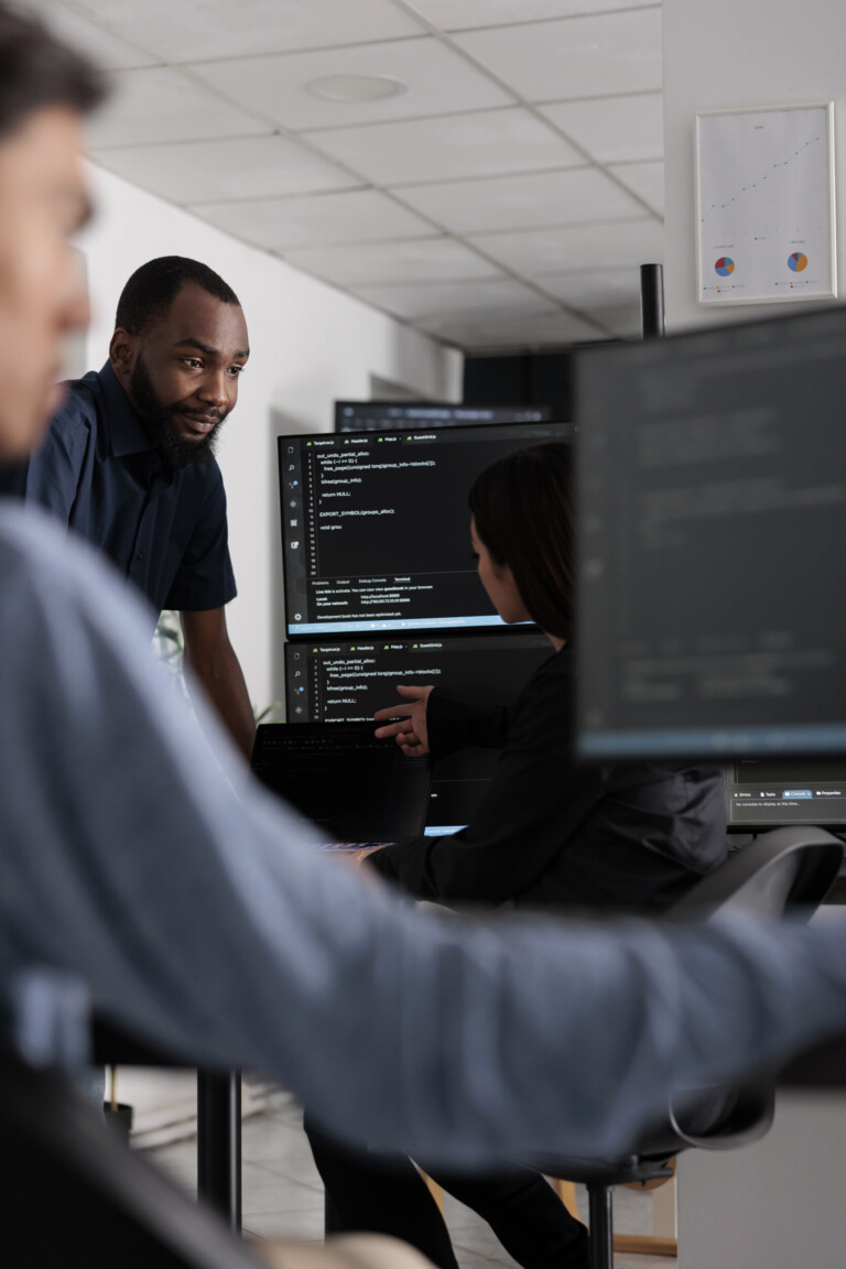 multi ethnic team of software developers talking about html code